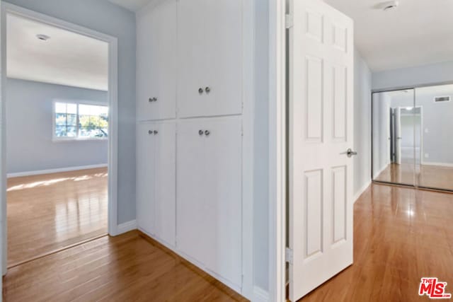 hallway with light hardwood / wood-style flooring