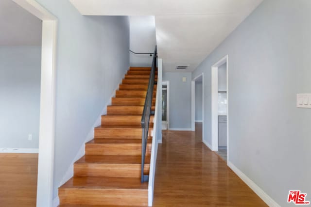 stairs featuring hardwood / wood-style floors