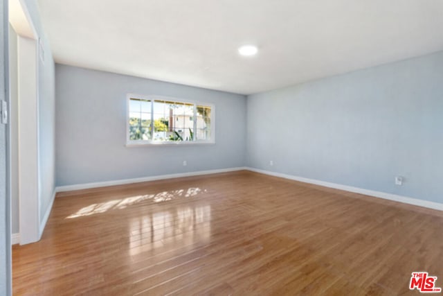 unfurnished room with wood-type flooring