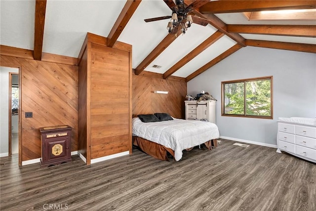 bedroom featuring vaulted ceiling with skylight, ceiling fan, dark wood-type flooring, and wood walls