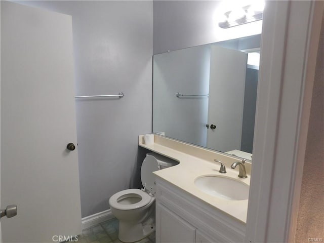 bathroom featuring vanity, toilet, and baseboards