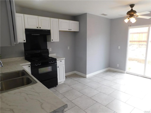 kitchen featuring white cabinets, a sink, black gas stove, and under cabinet range hood