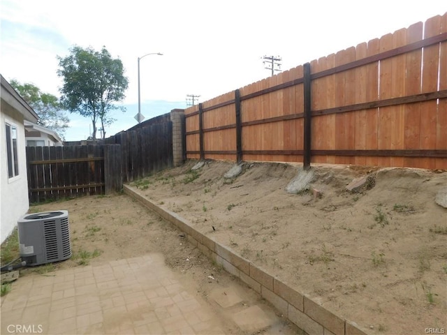 view of yard with central air condition unit and fence