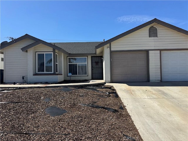 ranch-style home with a garage, a shingled roof, and concrete driveway