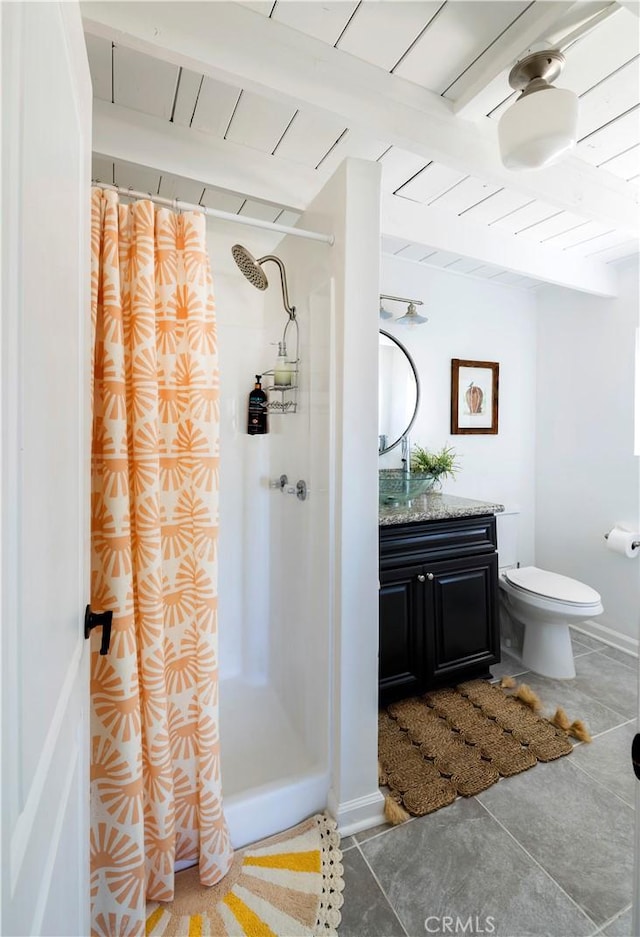 bathroom featuring tile patterned flooring, beamed ceiling, vanity, and walk in shower