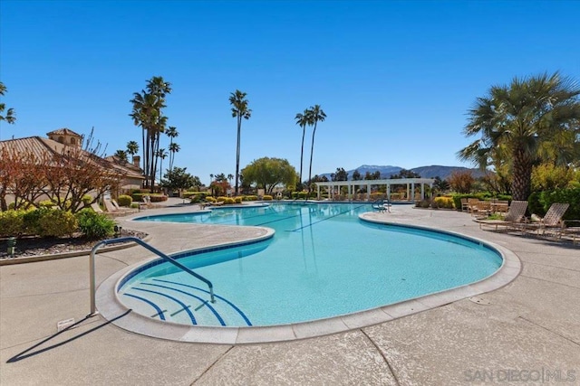 view of swimming pool with a patio area and a mountain view