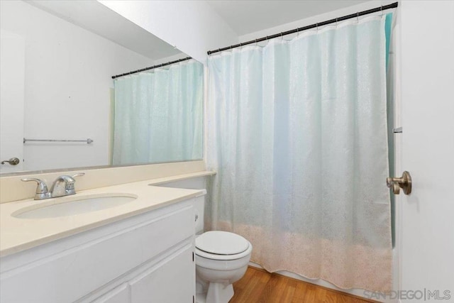 bathroom with vanity, hardwood / wood-style flooring, toilet, and walk in shower