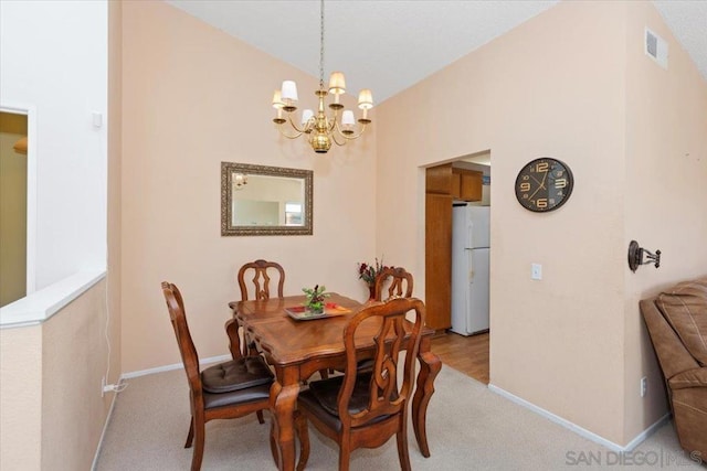 carpeted dining area featuring a notable chandelier