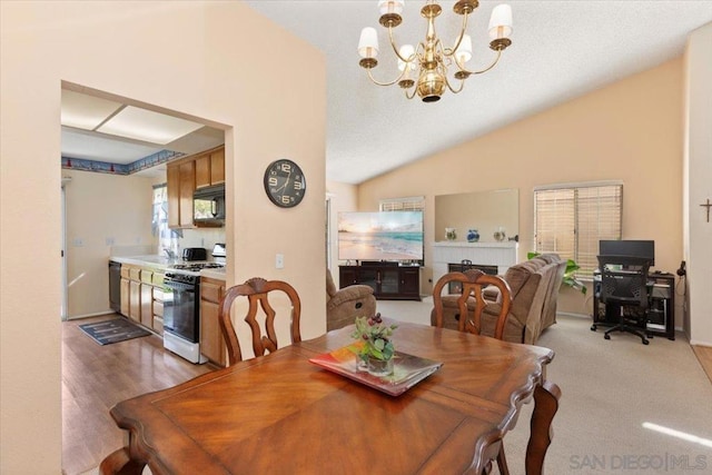 dining area featuring sink, vaulted ceiling, a notable chandelier, and wood-type flooring