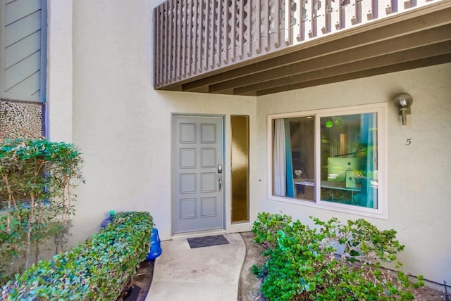 view of exterior entry featuring a balcony