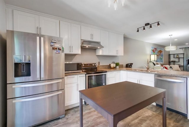 kitchen with sink, light hardwood / wood-style flooring, light stone countertops, white cabinetry, and stainless steel appliances