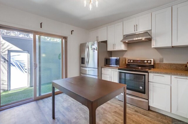 kitchen featuring white cabinets, light hardwood / wood-style floors, light stone countertops, and stainless steel appliances