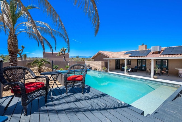 view of swimming pool with a wooden deck, outdoor lounge area, and central AC unit