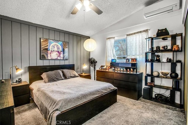 bedroom with ceiling fan, a wall mounted air conditioner, lofted ceiling, a textured ceiling, and carpet