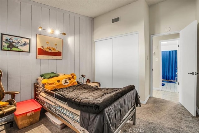 bedroom with a closet, carpet, and a textured ceiling