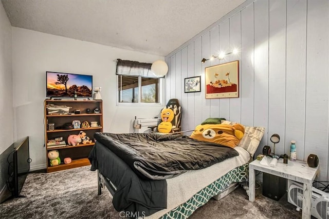 bedroom with carpet, a textured ceiling, and wood walls