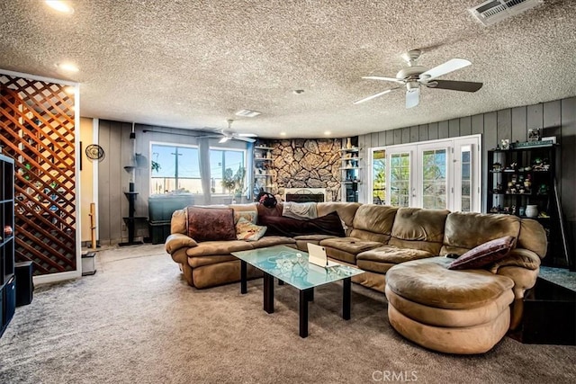 living room with french doors, a textured ceiling, carpet floors, and ceiling fan