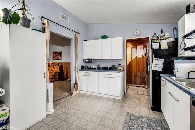 kitchen with sink, lofted ceiling, a textured ceiling, white cabinets, and appliances with stainless steel finishes