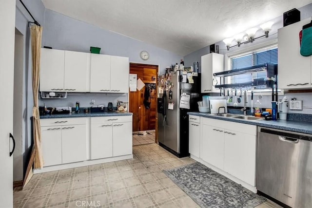 kitchen with white cabinetry, sink, a textured ceiling, lofted ceiling, and appliances with stainless steel finishes