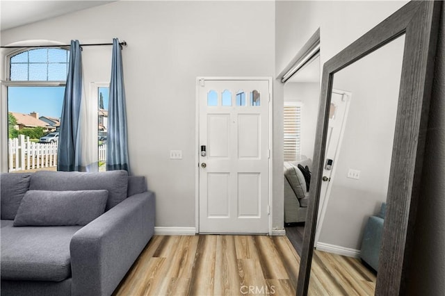 foyer entrance with light hardwood / wood-style floors and lofted ceiling