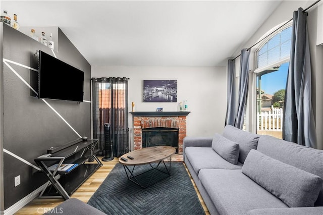 living room featuring lofted ceiling, wood-type flooring, and a fireplace