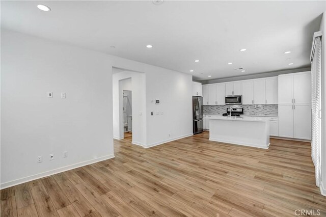 15974 Jamie Ln Unit 1, Fontana, CA 92336 - kitchen featuring appliances with stainless steel finishes, recessed lighting, white cabinets, light countertops, and tasteful backsplash