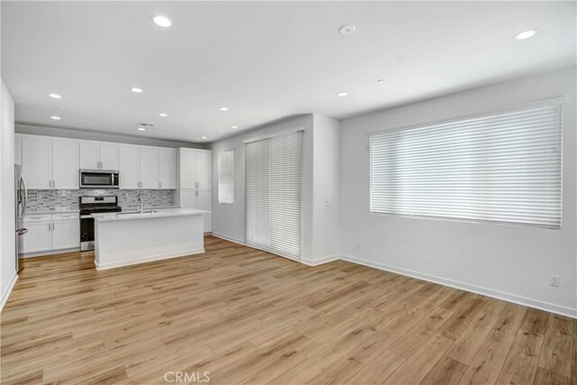 15974 Jamie Ln Unit 1, Fontana, CA 92336 - kitchen with stainless steel appliances, baseboards, recessed lighting, white cabinets, and tasteful backsplash