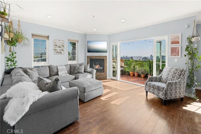 living room featuring a fireplace, dark hardwood / wood-style flooring, plenty of natural light, and ornamental molding