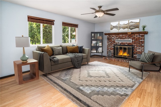 living room featuring hardwood / wood-style floors, a brick fireplace, and ceiling fan