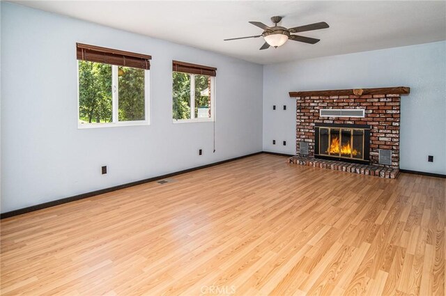 unfurnished living room featuring ceiling fan, a fireplace, and light hardwood / wood-style flooring