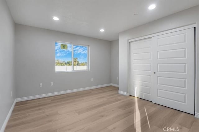 unfurnished bedroom featuring a closet and light hardwood / wood-style flooring