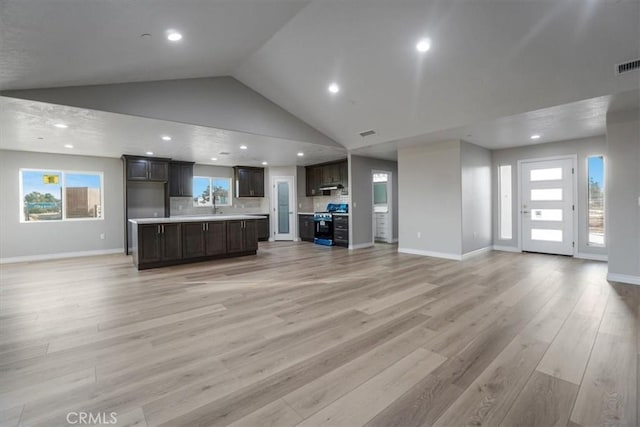 unfurnished living room with high vaulted ceiling and light hardwood / wood-style floors