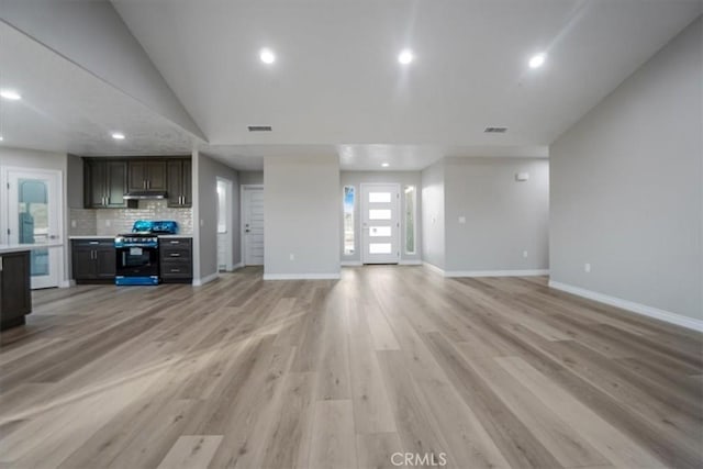 unfurnished living room with vaulted ceiling and light hardwood / wood-style flooring