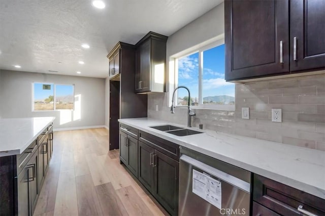 kitchen featuring stainless steel dishwasher, light hardwood / wood-style floors, a healthy amount of sunlight, and sink