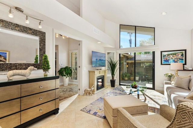 tiled living room featuring high vaulted ceiling and track lighting