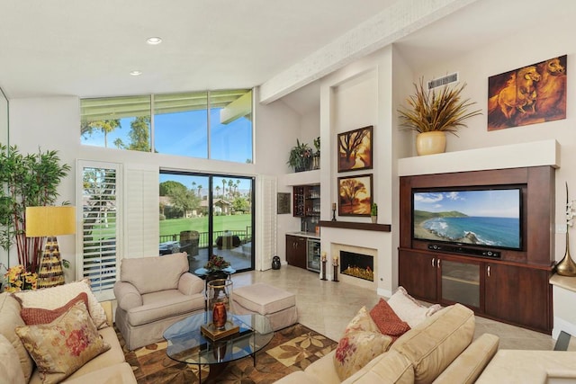 living room featuring vaulted ceiling with beams and light tile patterned floors