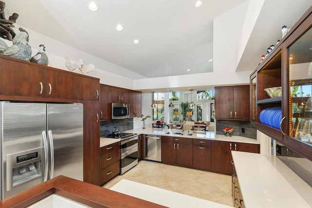 kitchen with kitchen peninsula, backsplash, stainless steel appliances, sink, and light tile patterned floors