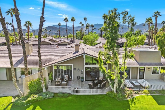 rear view of property featuring a lawn and a mountain view