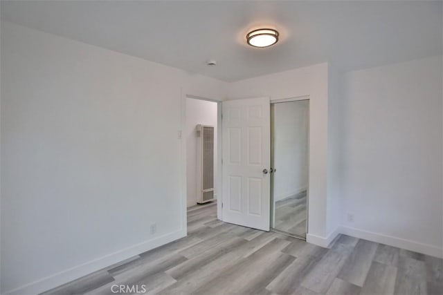 unfurnished bedroom featuring light hardwood / wood-style floors and a closet