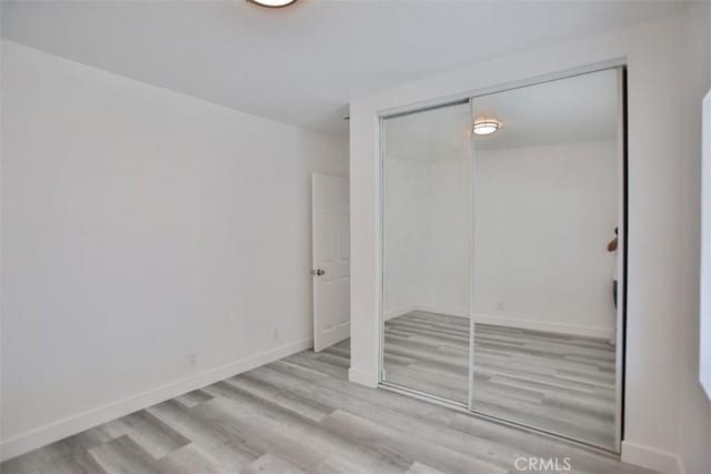 unfurnished bedroom with a closet and light hardwood / wood-style flooring