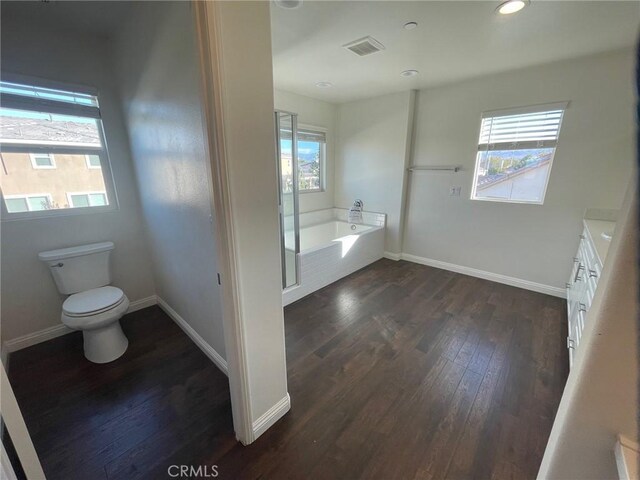 bathroom featuring vanity, hardwood / wood-style flooring, toilet, and a bathing tub