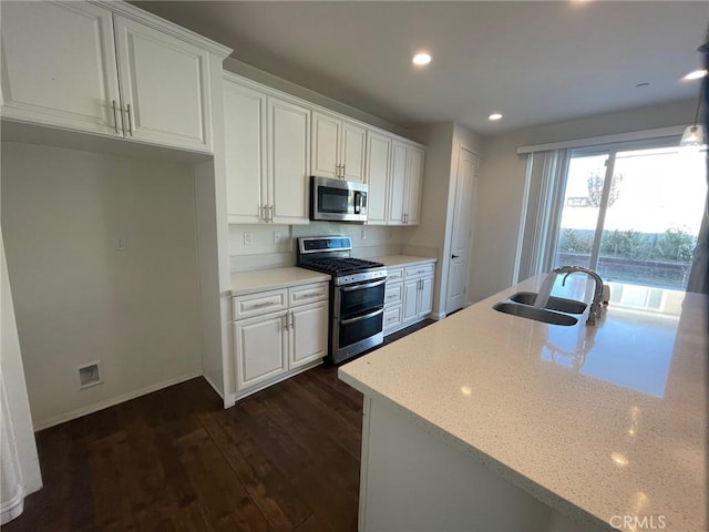 kitchen with stainless steel appliances, white cabinetry, dark hardwood / wood-style floors, and sink