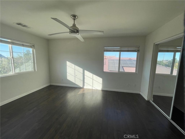 unfurnished room with dark hardwood / wood-style flooring, ceiling fan, and a healthy amount of sunlight