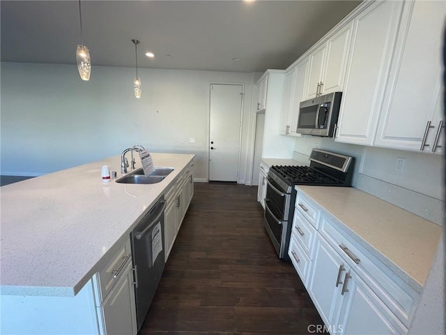 kitchen with appliances with stainless steel finishes, dark hardwood / wood-style flooring, white cabinetry, and sink