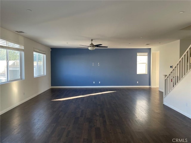 empty room featuring dark hardwood / wood-style floors, a wealth of natural light, and ceiling fan