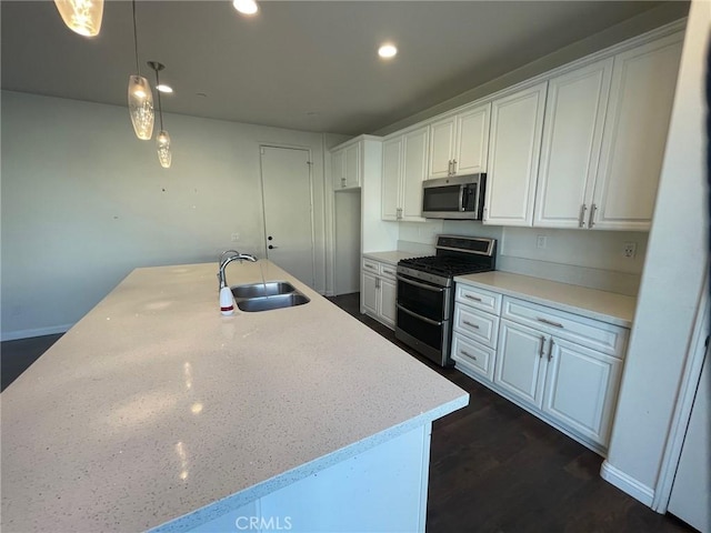 kitchen with light stone countertops, white cabinetry, dark wood-type flooring, pendant lighting, and appliances with stainless steel finishes