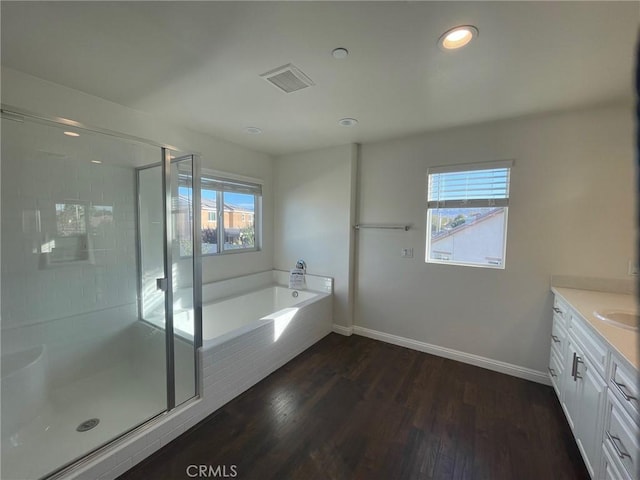 bathroom featuring plus walk in shower, wood-type flooring, and vanity