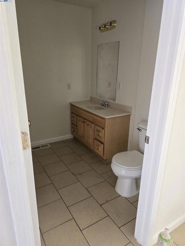 bathroom featuring tile patterned flooring, vanity, and toilet