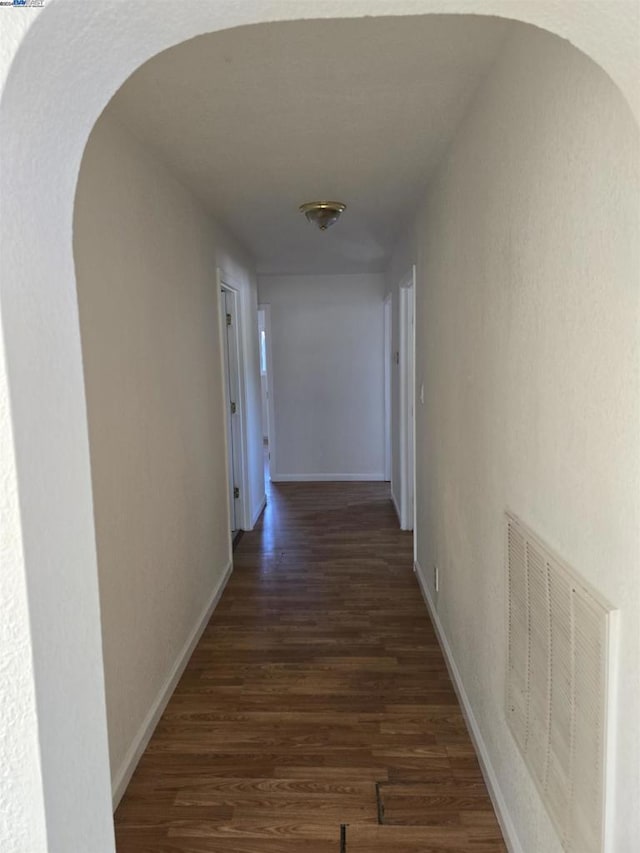 corridor with dark hardwood / wood-style flooring