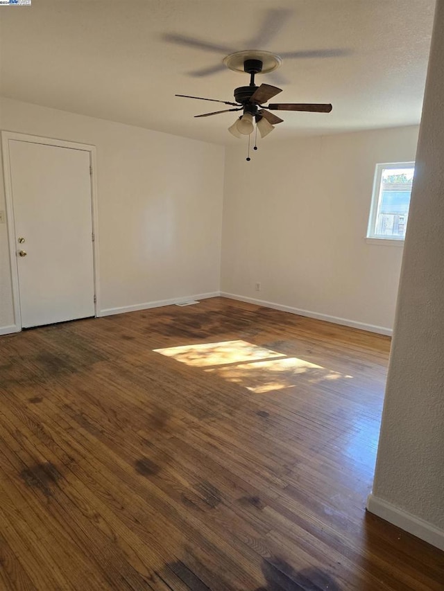 empty room featuring ceiling fan and dark wood-type flooring